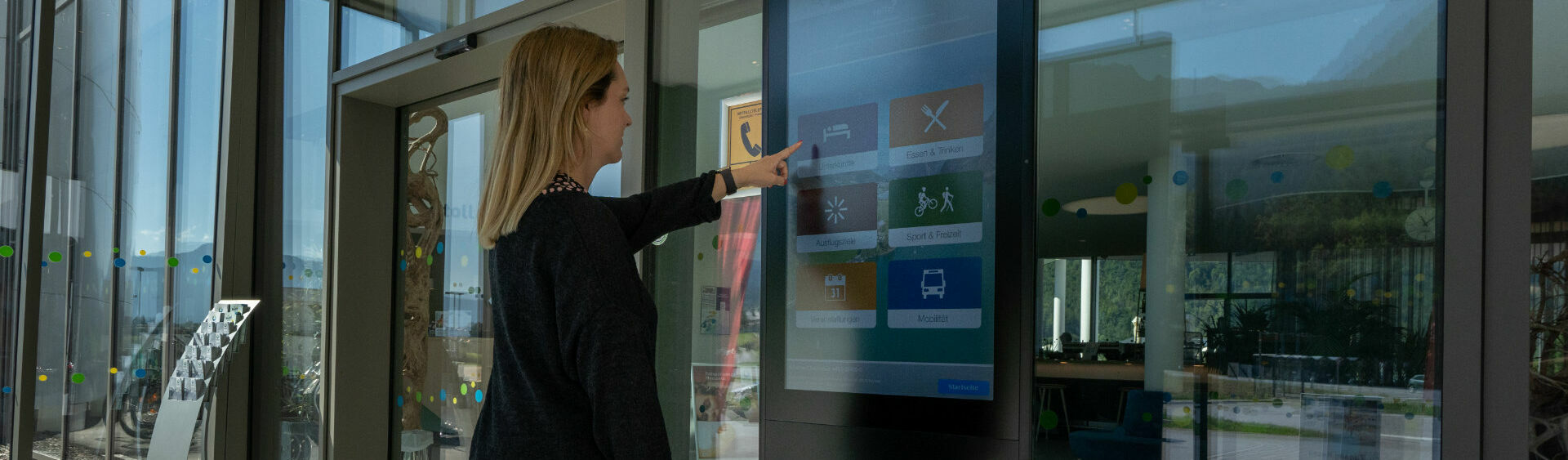 A woman gets information about the Achensee region at the information terminal in the Atoll Achensee.