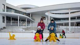 Eine Familie genießt den Wintertag auf dem Eislaufplatz des Atoll Achensee in Maurach.